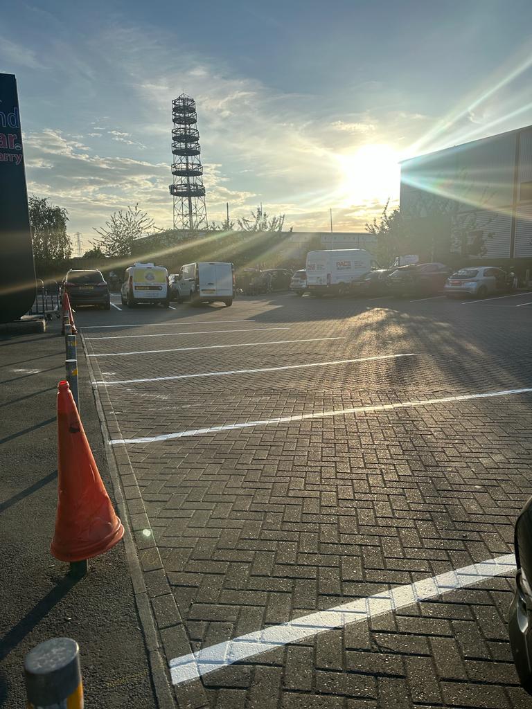 Commercial car park with new white bay markings on grey block paving