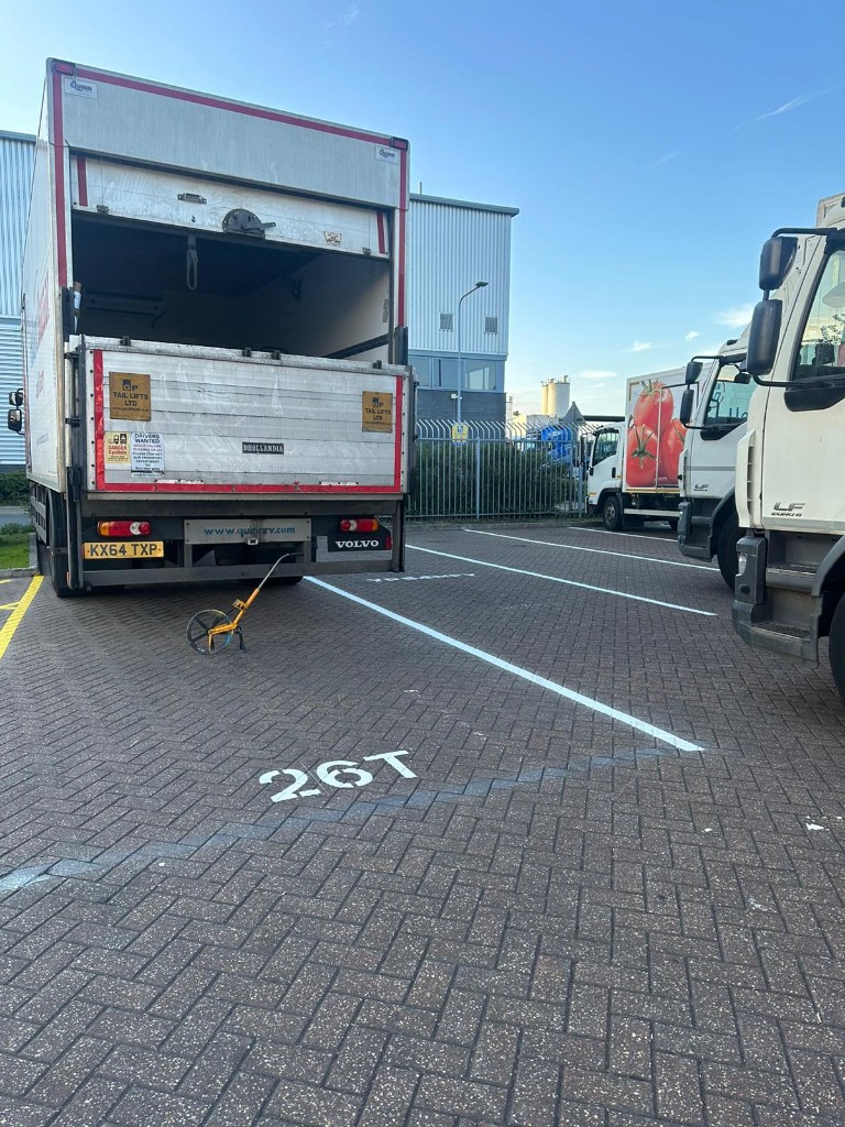 Commercial site — stencil and bay layout set-out with roller and measuring equipment on block paving