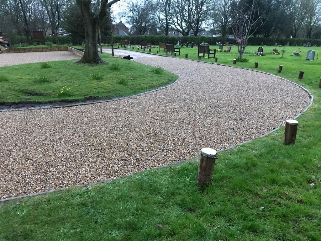 Curved gravel footpath with clean edging through landscaped public grounds