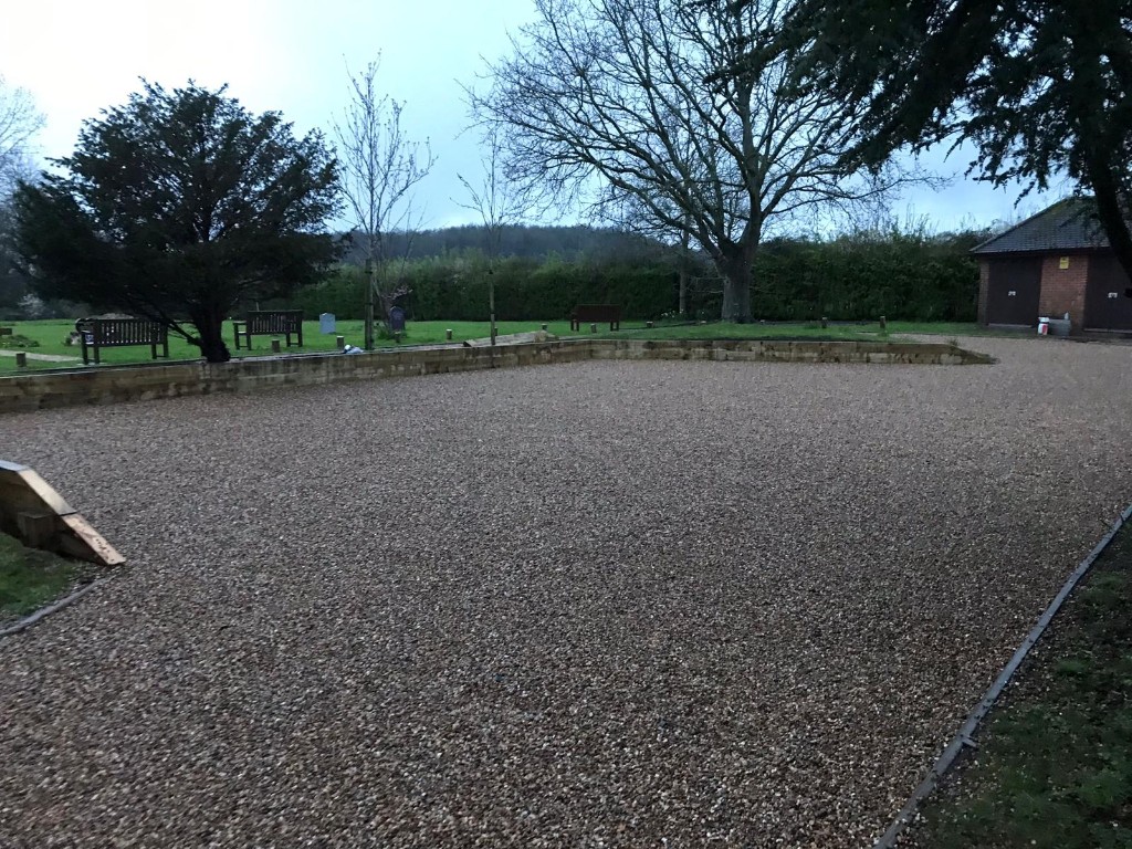 Expansive gravel hardstanding edged for parking at a public site