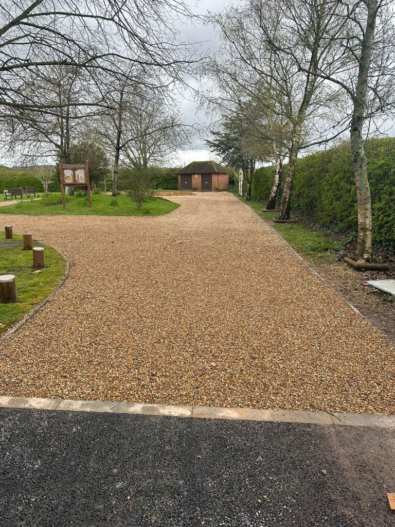 Gravel approach with landscaped borders leading to a utility building