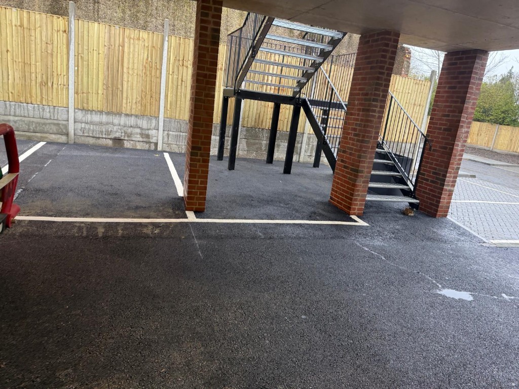 Covered parking — asphalt finish under concrete slab and brick piers