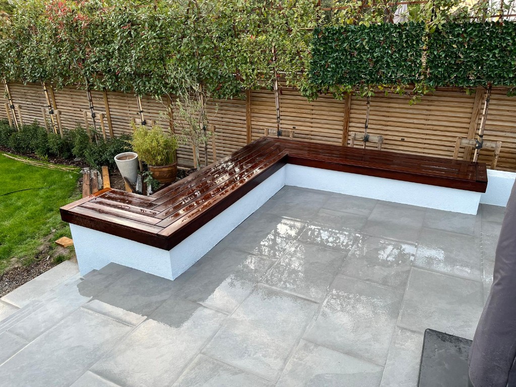 Garden room patio with external lighting and low garden walls framing the paved plane