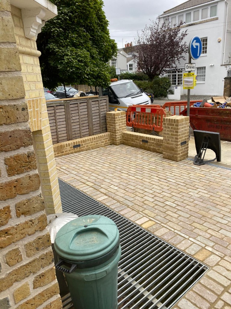 Outdoor staircase with red brick risers and retaining walls and dark stone treads