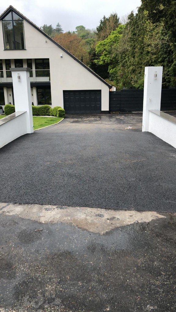 New machine-laid tarmac driveway with rendered entrance pillars and threshold detail