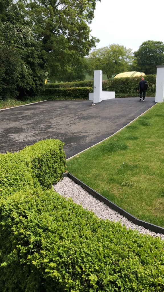 Large domestic tarmac bay with crisp margins, lawn and fencing