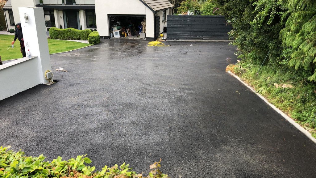 Wide newly laid tarmac driveway in front of a contemporary house