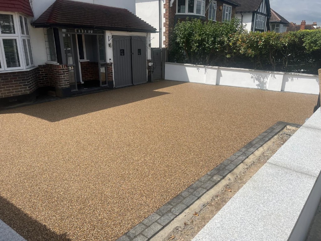 Natural stone patio with charcoal block edging beside a grey garden room with tall glazing
