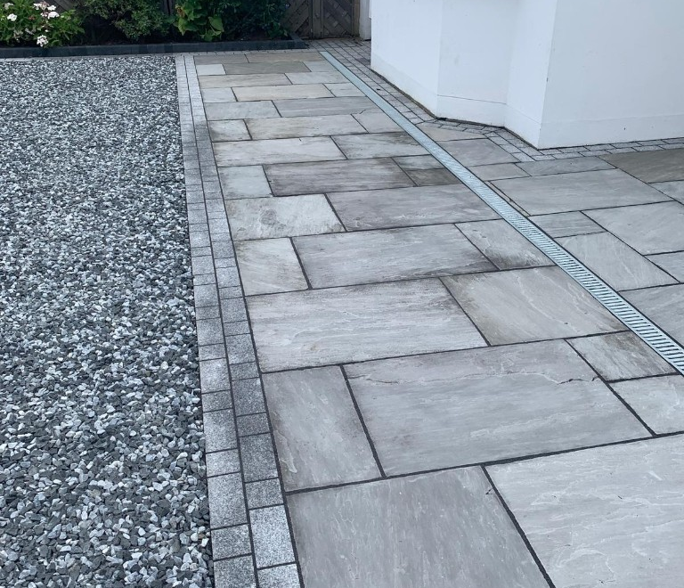 Indian sandstone paving with a contrasting border and discreet linear drainage