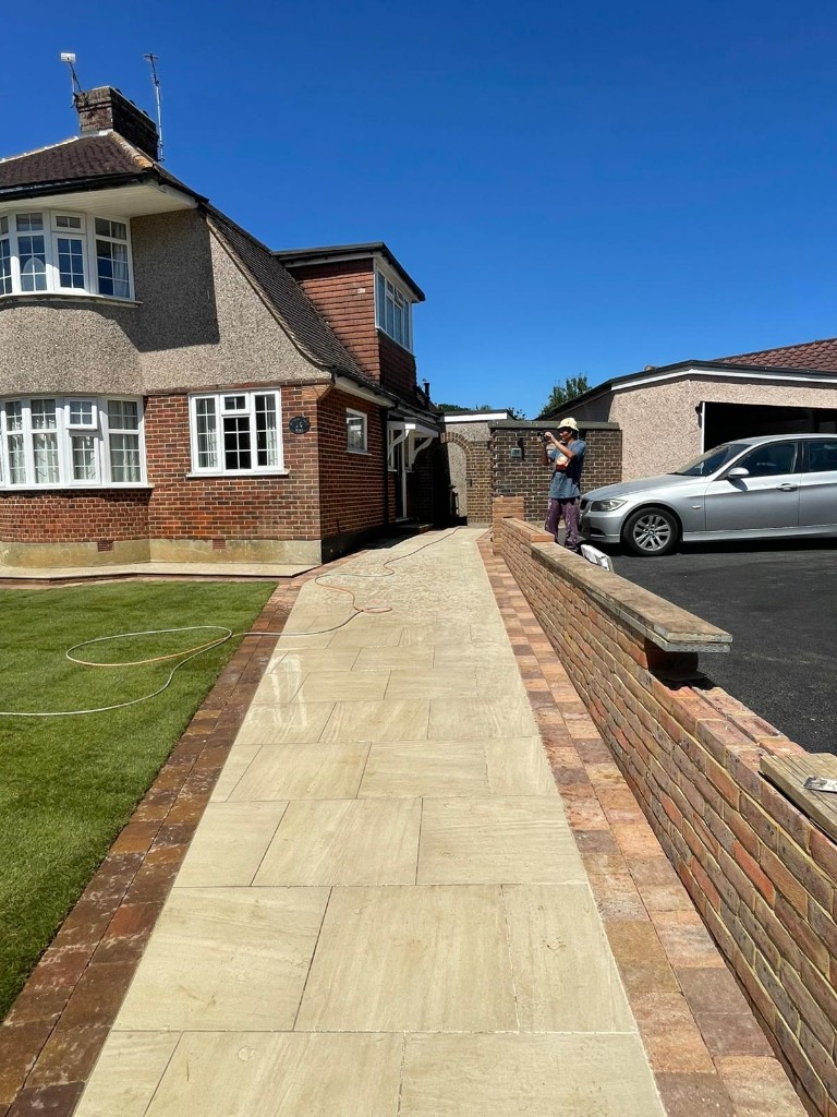 Long buff sandstone garden path with brick paver borders and green lawn
